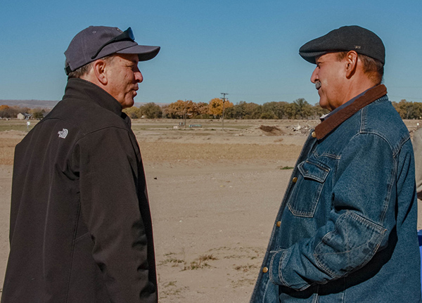 Two men talking in field