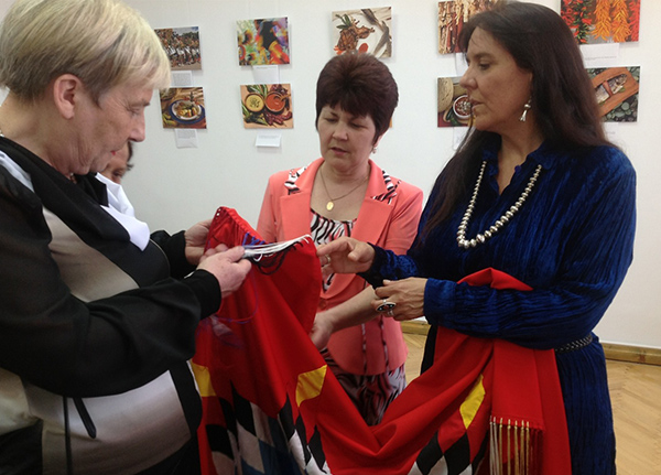 Three people looking at a tribal garment
