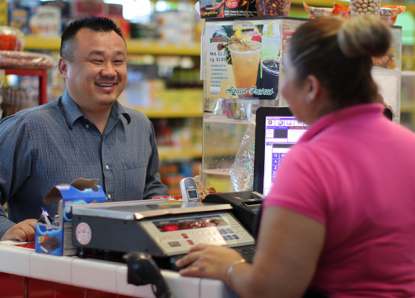Man smiles at store counter