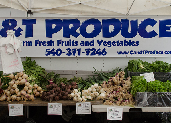 Booth with a produce sign and fresh veggies