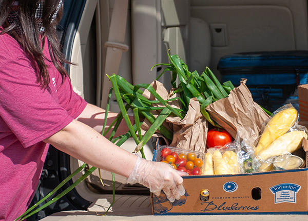 Woman grabbing a box of produce