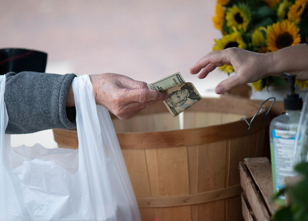 Person giving a twenty dollar bill to a vendor