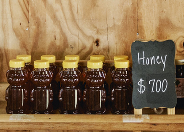 Honey on a shelf with a sign that says 'Honey $7'