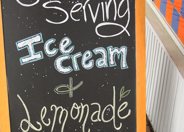 Handwritten sign that says 'Serving Ice Cream and Lemondade'