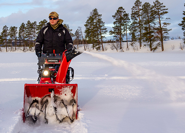 Man clearing path with a snow blower