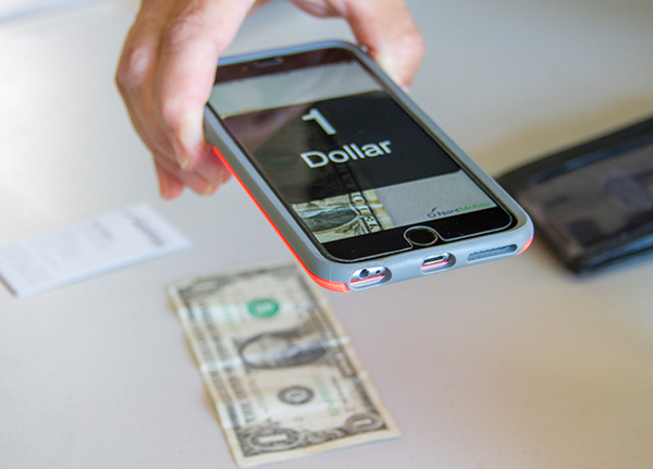 Assistive phone app that is scanning a dollar bill and displaying large text that says '1 Dollar'