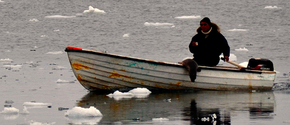 Man in fishing boat in arctic water