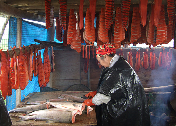 Woman cleaning and fileting salmon