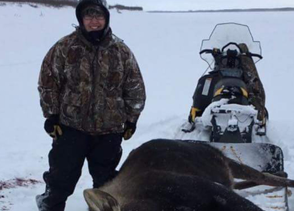 Woman poses with a hunted moose