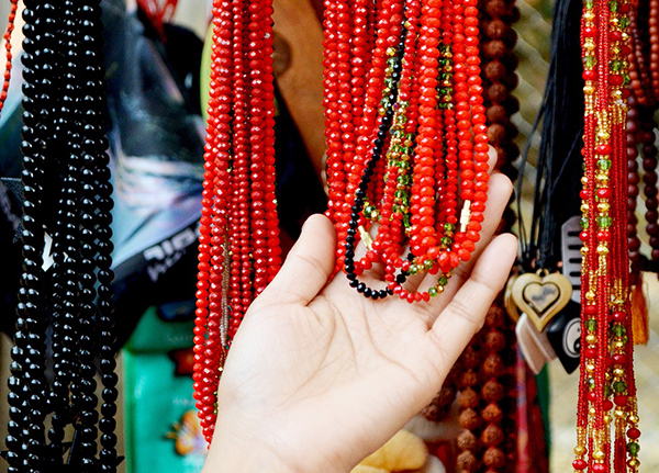 Hand holding beaded necklaces