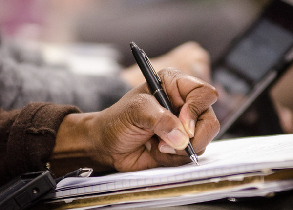 Hand writing on notepad with pen