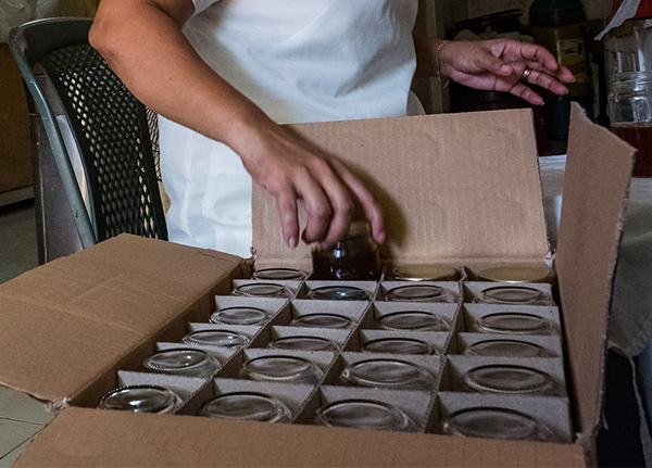 Person puts jars in a box