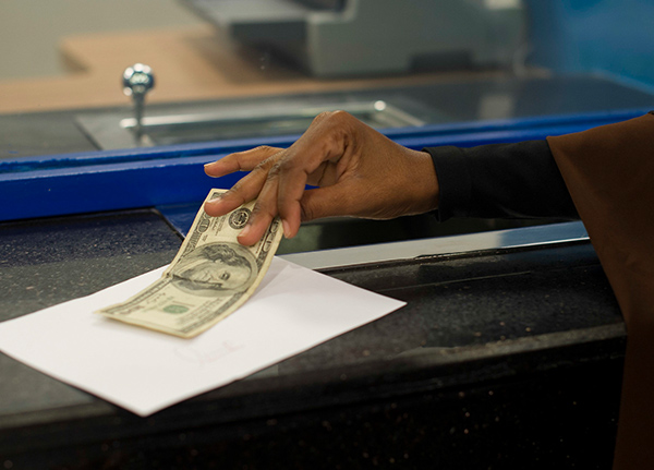 Hand grabbing a $100 bill