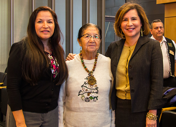 Three women smile and pose for the camera