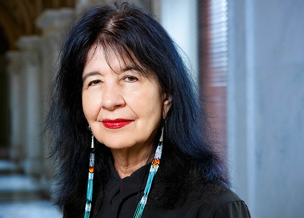 Woman with long beaded earrings smiles at the camera