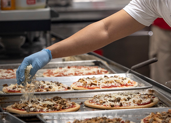 Person making pizzas