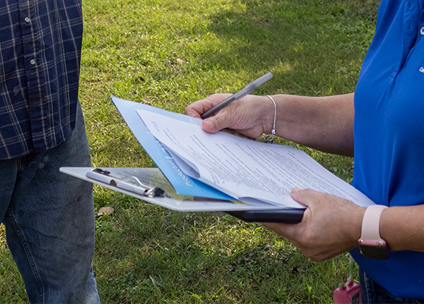 Person holding clipboard and pen