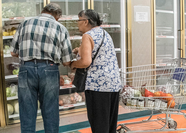 Couple in the frozen section of a grocery store