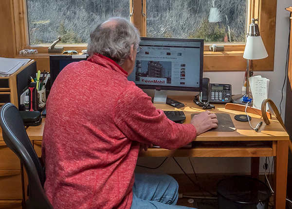 Man looking at a computer in a home office