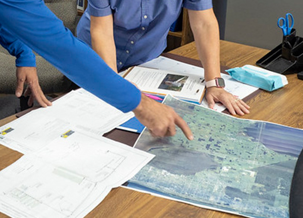 Person pointing to map on table