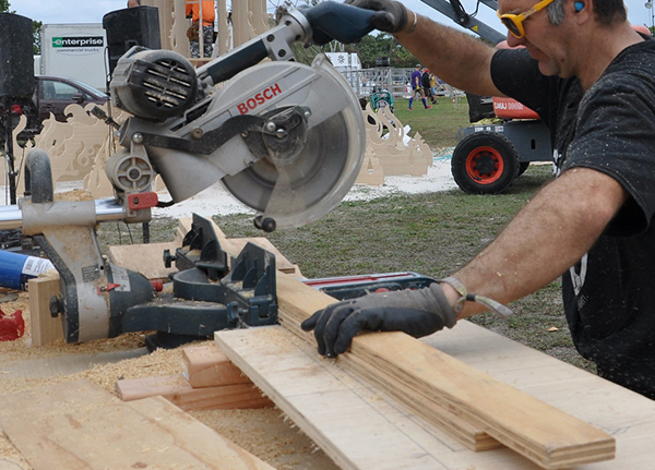 Man saws wood boards