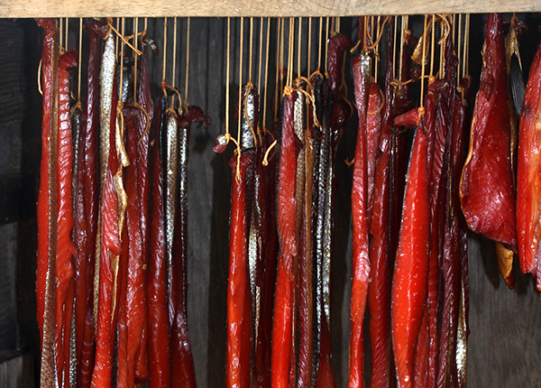 Salmon hanging from strings getting smoked