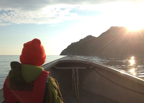 Person in boat with sunrise in the background