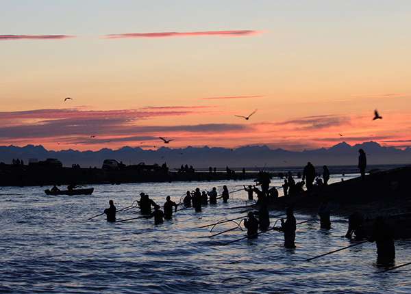 Fishermen in river with nets at sunrise