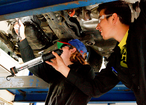 Young mechanic holding car part